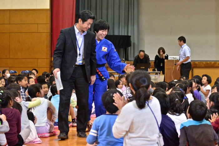 港南第二小学校で講演する半谷静香。山手英樹校長先生に手引きしてもらいハイタッチしながらお別れ