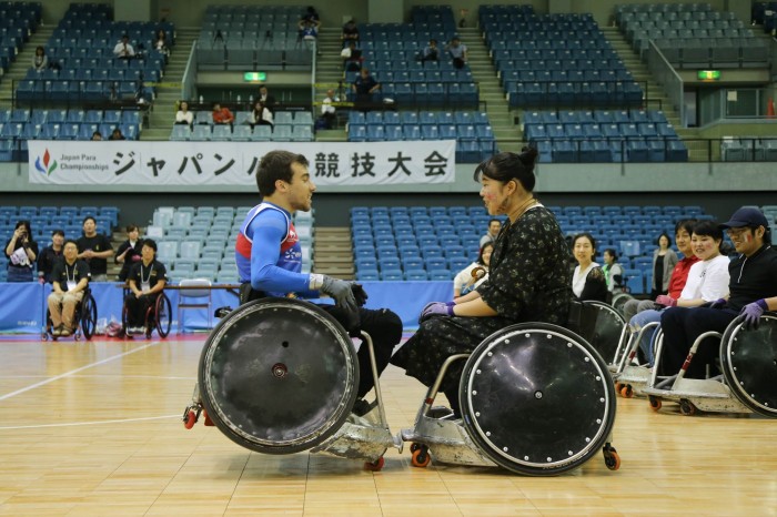 ブレイクタイムの体験コーナーでフランス選手のタックルを受ける専門学校生の長谷川さん（写真・内田和稔）